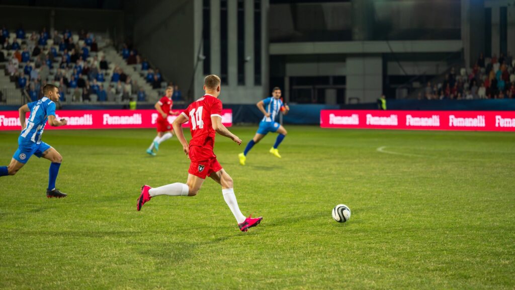 Male soccer players leading ball